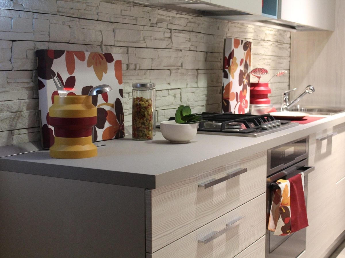 Galley kitchen with pale doors against a stone wall